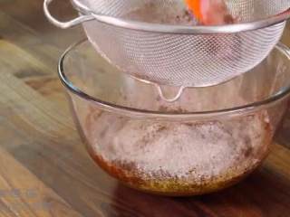 3、摩卡戚风蛋糕,面粉和可可粉过筛倒入,用蛋抽搅拌成蛋黄糊