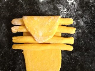 8、螃蟹馒头,分别将条状放在面皮上，将面皮的一端向内折