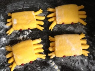 10、螃蟹馒头,将螃蟹翻过来，摆好造型并剪出蟹钳，用红豆点缀眼睛