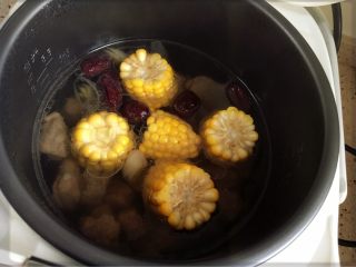 4、电饭煲版玉米炖排骨,加入料酒和切段的玉米。炖煮一小时。