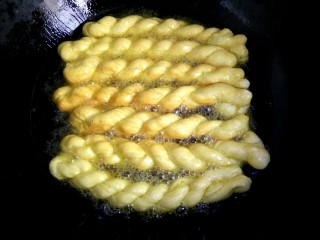 12、炸麻花,油热，放入麻花，待麻花全部漂起，一面炸至金黄，用筷子翻面