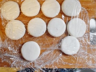 16、紫薯山药糯米饼（微笑饼）,做好的饼，用保鲜膜盖住。