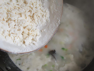 9、肉丝木耳疙瘩面汤,锅中汤正好煮开放入木耳和炒熟的肉丝、胡萝卜、西葫芦。再倒入絮状面片,搅匀