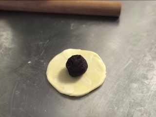 11、白皮酥,将面团按扁,檊开,不要檊太多,放入一颗馅料。