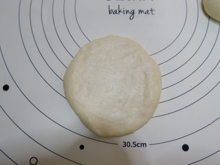 9、椰蓉菊花面包,收口向下，用擀面杖擀大擀薄一点。擀好放在烤盘上。