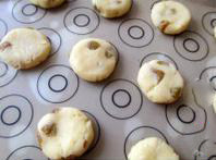 8、丹麦蓝罐曲奇,把小面剂用手揉圆、压扁，放在铺了油布的烤盘上，入预热至180度的烤箱，中层，上下火，烤15分钟，颜色变黄即可取出。