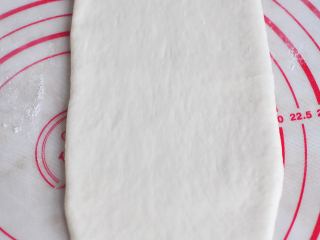 9、葡萄干麻糬软欧,取一个面团，排气后擀成牛舌状。