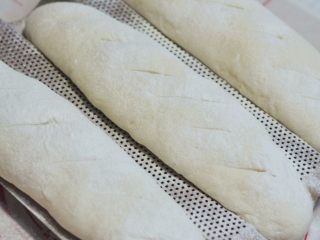 12、葡萄干麻糬软欧,面团发酵40分钟，在表面筛上一些高粉，割些斜口，烤箱预热好后，180度烘烤25分钟。