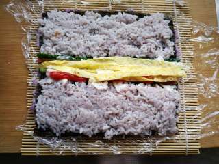 8、翻转花朵寿司, 中间放入切好的黄瓜条、火腿条、蛋饼条，挤上番茄酱。抹一层沙拉酱。