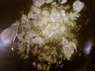 5、红烧肉,锅中重新放油,小火加温。手抓一把冰糖放入,用锅铲快速翻炒,一定要快速,且一定要小火,否则冰糖会糊。直到冰糖全部溶化呈焦糖色的液态状。