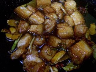 6、红烧肉,待冰糖溶化后开始冒小泡时(冒小泡的时候是最佳状态),将刚刚盛出的五花肉以及所有香料再次入锅,改中火翻炒,使五花肉能均匀沾上糖汁。
