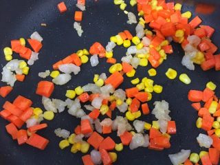 6、宝宝辅食12M➕：南瓜虾仁芝士吐司布丁,锅里刷一层薄薄的油，先放入胡萝卜丁翻炒至断生，然后再依次加入玉米粒和虾末，三分钟后盛出备用。