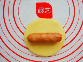 7、＃甜味＃暖暖熊香肠烧果子,面团平均分成两份，取一份擀片状，放入香肠。