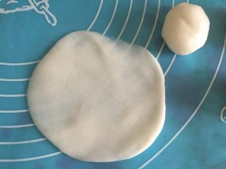 7、紫薯冰皮月饼（简易版）,取一个冰皮丸子，用手掌稍稍按压，呈中间厚周围薄的饼，不要太薄哦，不然会显露里面的馅料颜色，影响外观。