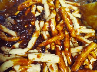 9、红糖酥,倒入炸好的面条酥，也可以加上少量葡萄干或是让坚果等，翻拌均匀，让每个面条酥都能裹上红糖汁