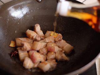 9、【再添一碗饭】の土豆炖猪肉,倒入适量料酒，继续翻炒均匀