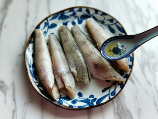 5、#做妈妈的拿手菜#红烧冰鱼段,再加入将处理好的南极冰鱼段放入器具中，加入食用盐，料酒，用手轻轻按摩。