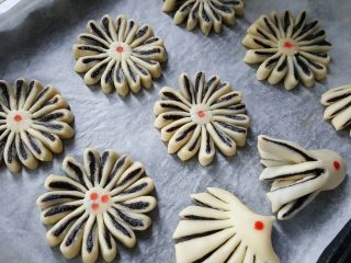 21、中式点心~玫瑰酥,所有的面胚制作完毕后，中间点上用红曲粉水加水稀释后的红点装饰。