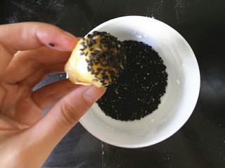 7、中式点心杏仁酥,冷藏好的面团取出，将面团以18克为一个小剂子，轻轻揉圆 然后在沾点黑芝麻在面团表面