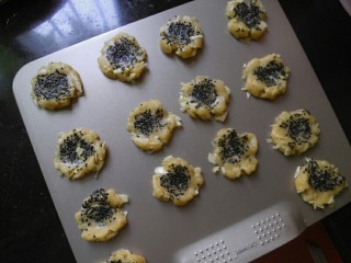 8、中式点心杏仁酥,把面团放入烤盘，用手掌 掌根部位对着面团轻轻压下去，使面团形成自然的裂痕。（烤箱预热177度）