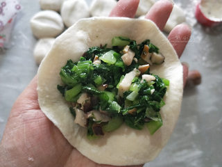 13、香菇青菜包子--不一样的做法, 放馅，素馅比较散，尽量多包点馅吧。青菜无可避免的会出一点水，包的时候把放馅的盆一边垫高，把馅拨到高的一边，让出的水流到另一边，避免包入的馅含水量大，毕竟我们不是包灌汤包哈哈。