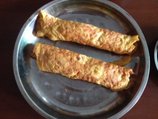 4、妈妈的爱心早餐,慢火两边煎至金黄，上碟卷成圆柱