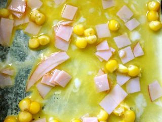 4、玉米蛋饼,关火，锅中放蛋液，将刚刚煎好的饼皮放在蛋液上，中火继续煎