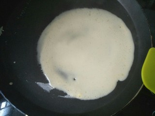 6、芒果班戟,平底锅加热后转小火，放入一勺面糊慢慢摊圆。