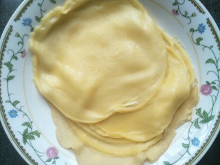 8、芒果班戟,将平底锅倒过来将面皮倒入盘中。