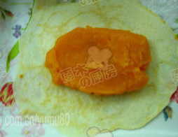 6、银包金,取出稍晾凉,将没煎那面朝下放.再放上一块南瓜泥,包卷一下,切块即可。