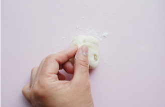 11、#夏天的味道#花朵豆沙酥,取一块松弛好的酥皮面团，两端向内捏并压扁；