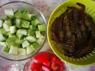 1、鲜虾番茄炒黄瓜丁,主要食材，将黄瓜和番茄切粒，黄瓜切粒后用适量盐腌腌，这样黄瓜煮熟后口感会很爽，好吃很多。大概腌十到二十分钟就可以，炒前用清水冲一冲，沥一沥多余水份。