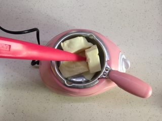 3、有内涵的麻将牌,白巧一共需要用大概200g，先拿出一半放到巧克力锅里，调到高温进行融化，不停搅拌固体巧克力，直至全部融化