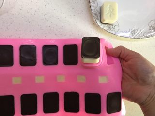 25、有内涵的麻将牌,双手食指将巧克力从模具中轻轻推出，所有麻将牌都用相同方法脱模