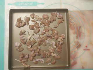 7、黑椒鸡肉披萨,趁着发酵的时间,做好其它准备工作。首先把腌制好的鸡腿肉平铺在烤盘上。