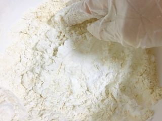5、从小吃到大都吃不腻的黑芝麻桃酥,戴上烘焙用的一次性手套，将搅拌盆内的粉类混合均匀。