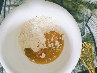 6、从小吃到大都吃不腻的黑芝麻桃酥,混合均匀的粉类有着漂亮的小麦色，淡淡的，接着倒入玉米油和融化成液体的黄油。