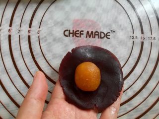 13、广式红豆沙蛋黄月饼,取一个豆沙馅球按扁包上凤梨馅