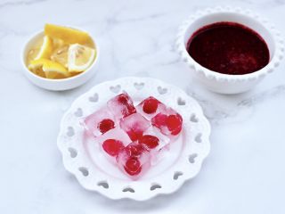 6、蔓越莓桑葚气泡水,把柠檬洗净后用刀切成片,榨好的蔓越莓桑葚汁盛到碗里,把冷冻好的冰块取出脱模。