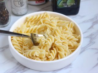 6、芝士意粉,捞出意面放盘子中,加一勺橄榄油先拌匀,以免互相黏连。