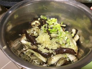 4、韩式凉拌茄子,茄子放凉以后，手撕成茄条。再放入蒜末，葱末。