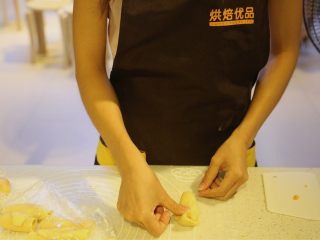 15、不一样的黄金月饼酥,松弛好的面团,收口朝上,用拇指在面卷中间压一下,两边往上折,压平