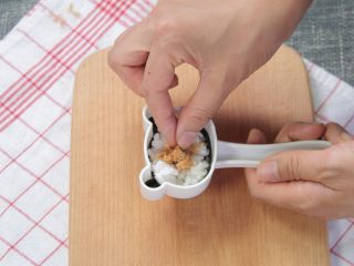 3、让熊孩子爱上吃饭的熊猫饭团,在模具中放上一层米饭，再放上一层肉松，最后放上米饭，用模具压出小熊猫的样子
