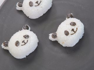 11、让熊孩子爱上吃饭的熊猫饭团,将海苔压出的鼻子眼睛和耳朵贴在饭团上
