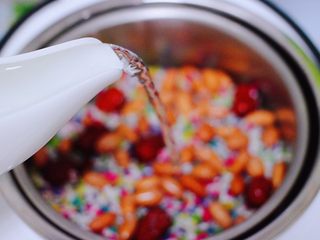 6、红枣花生五彩饭,这时候倒入适量的清水，水不要超过食材的1厘米以上哟，这个“臻米脱糖电饭煲”的工作原理和我小时候吃的捞米饭是同一个原理，米饭放水里煮至半熟，用漏网捞出半熟的米饭，再将它放锅里蒸熟。