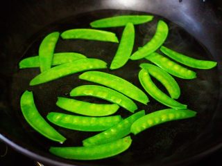 3、六鲜菌菇海鲜豆腐什锦汤,锅中倒入适量清水煮沸后，加入一勺盐后把荷兰豆进行焯水。