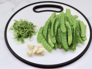 2、鲜鱿爆荷兰豆,荷兰豆去除筋膜，大蒜去皮。
