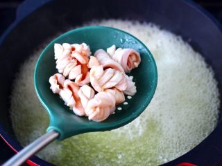 5、鲜鱿爆荷兰豆,用焯荷兰豆的热水，加入料酒放入鱿鱼进行焯水，看见鱿鱼变白成卷的时候，捞出沥干水分备用。