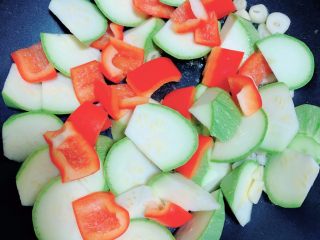 11、照烧鸡胸蔬菜酿皮,放入西葫芦和红椒，翻炒均匀。