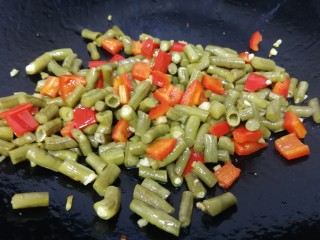 14、酸豆角炒肉末,放入酸豆角，文火翻炒均匀，把酸豆角里面的水份炒干，底油的香味炒入酸豆里面，多炒一会儿。